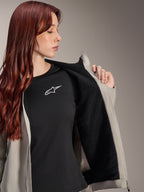 Kvinde iført Alpinestars Stella A-Dura Thermal Jacket i Titanium, som viser det sorte teksturerede fleecefor, båret over en sort t-shirt med hvidt stjernelogo, letvægts mountainbikejakke til kolde forhold