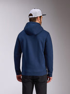 Alpinestars Frontal hættetrøje, marineblå pullover fleece, set bagfra, afslappet streetwear, båret med sorte bukser og en hvid og sort mesh-kasket, moderne motorsport-inspireret design