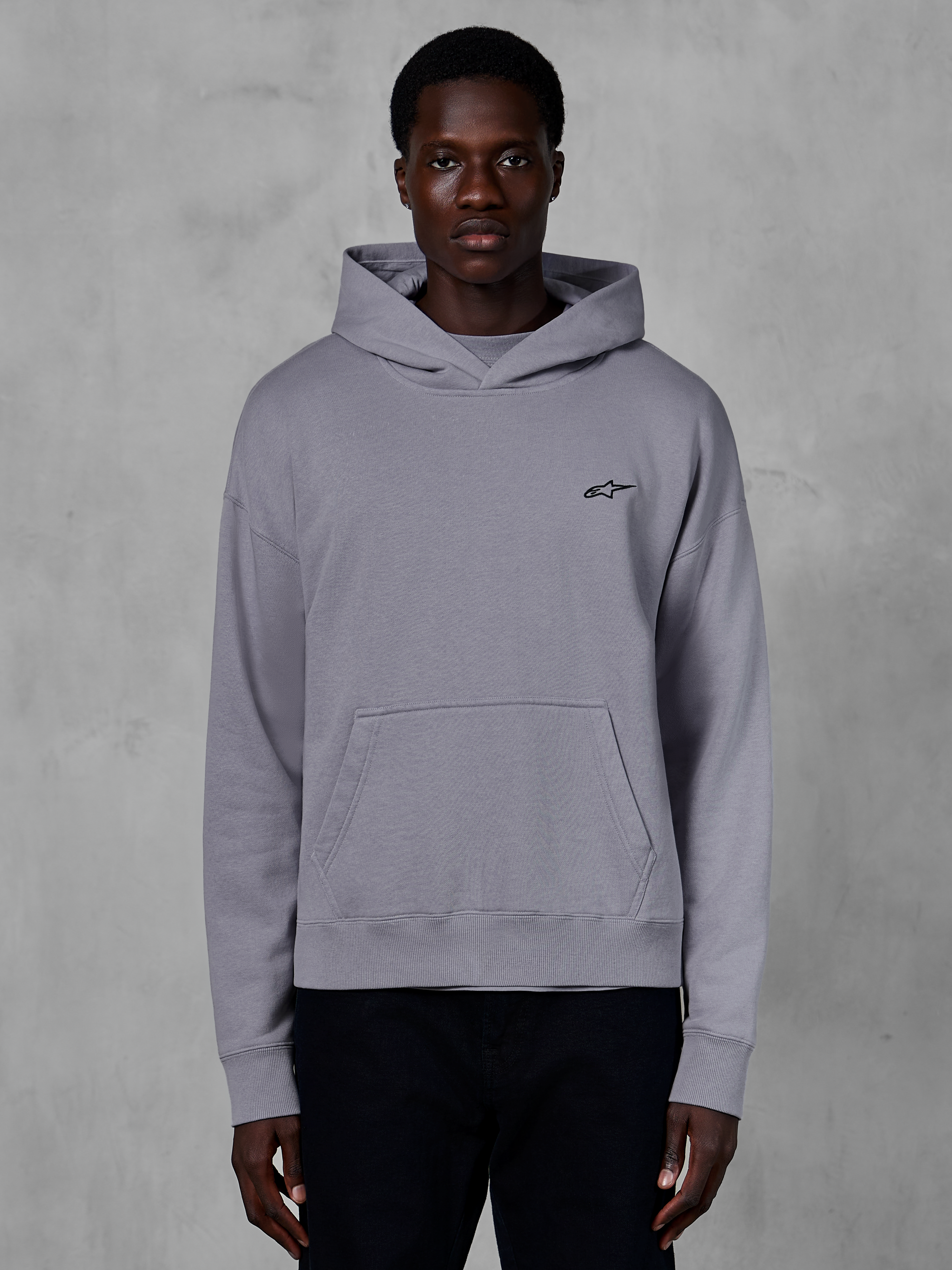 Alpinestars Essentials Ageless Hoodie, sølvfarvet hættetrøje, afslappet streetwear, med et lille sort Astars-logo på brystet, kængurulomme foran, hætte med crossover-hals og en blød stenvasket finish.