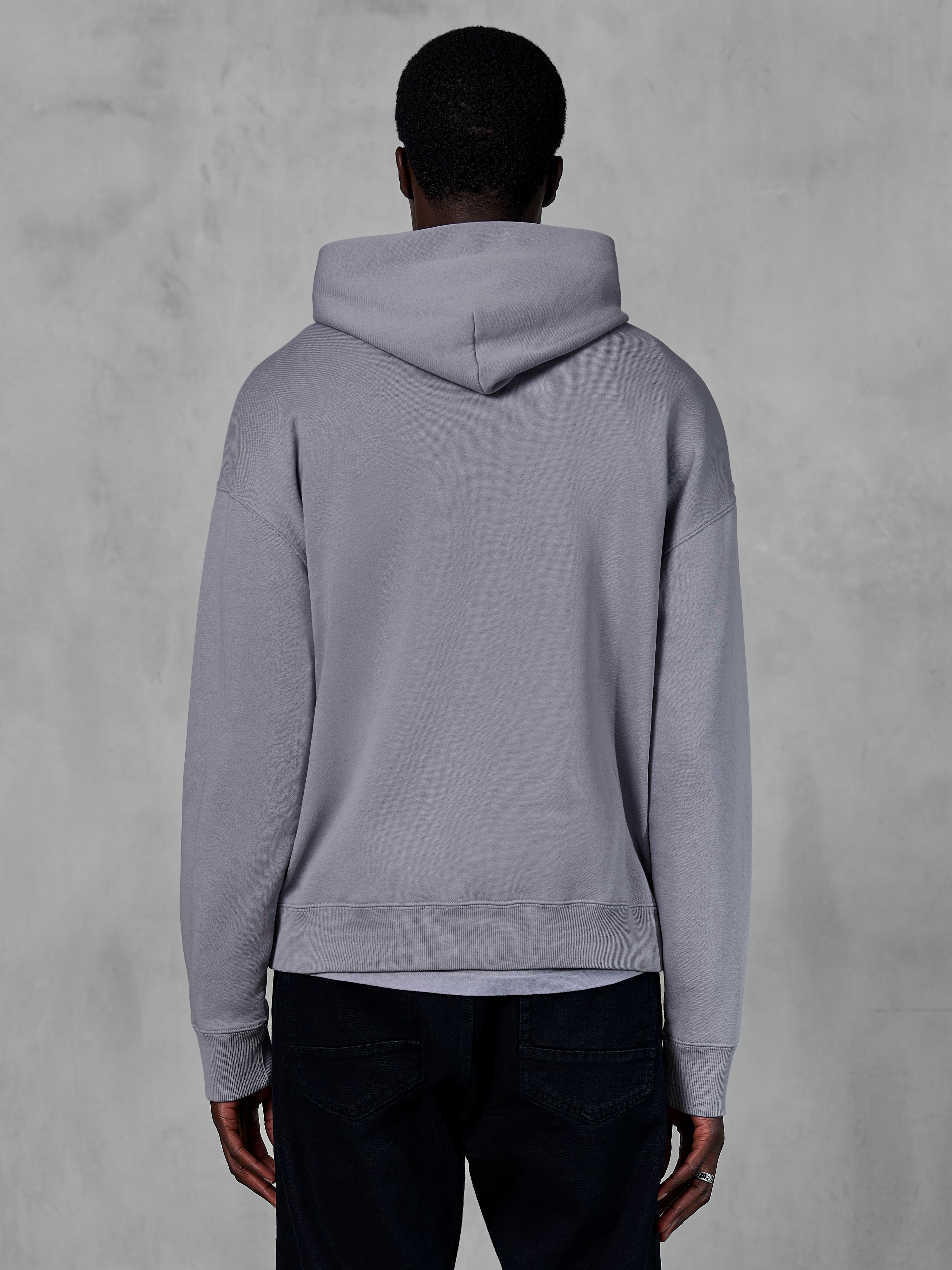 Alpinestars Essentials Ageless Hoodie, sølvgrå fleece, set bagfra, minimalistisk pullover-design med hætte og ribbede manchetter, afslappet motorsport-inspireret streetwear