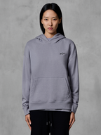 Alpinestars Essentials Ageless Hoodie, afslappet sportstøj, sølvfarvet med lille sort logo, kængurulomme, hættetrøje, båret af model, moderne livsstilsbeklædning