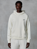Alpinestars Essentials Ageless hættetrøje, off-white, båret af en mandlig model, lille sort logo på brystet, kængurulomme foran, lange ærmer, afslappet motorsport-inspireret streetwear