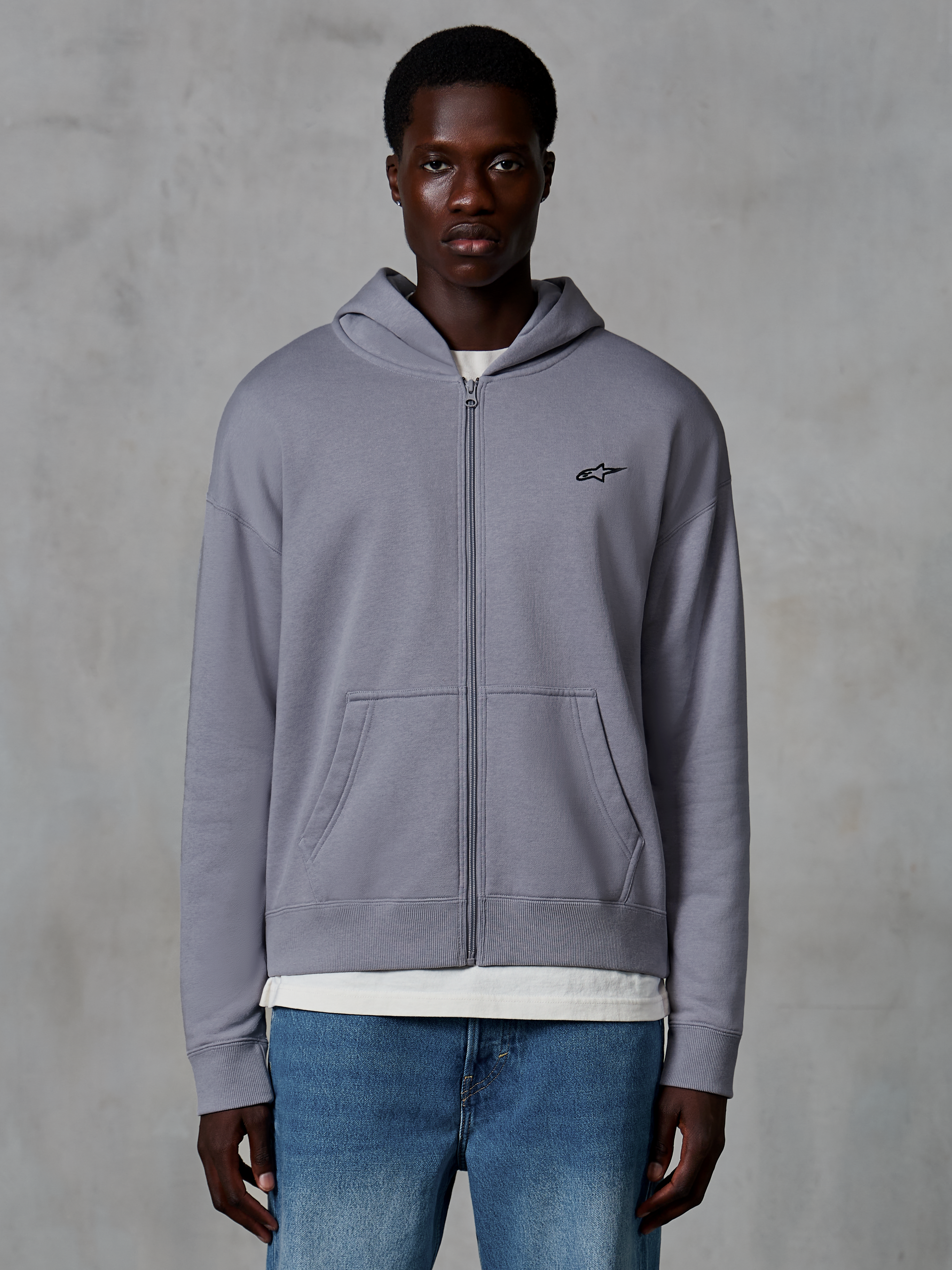 Alpinestars Essentials Ageless Zip hættetrøje, sølv, afslappet streetwear båret af model, fleece med fuld lynlås og lille sort Astars-logo på brystet, kængurulommer, design med afslappet pasform