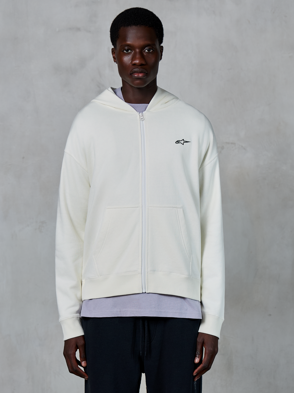 Alpinestars Essentials Ageless Zip Hoodie, afslappet råhvid sweatshirt med lynlås, hætte med snøre, ribbede manchetter og kant, diskret branding, førsteklasses motorsport-inspireret livsstilstøj