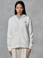 Alpinestars Essentials Ageless Zip Hoodie, Off White, fleece-sweatshirt med lynlås båret af en model, med et lille sort Astars-logo på brystet, afslappet pasform, afslappet motorsport-inspireret livsstilstøj