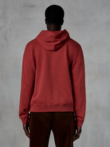 Alpinestars Essentials Ageless Zip Hoodie, teglrød, set bagfra, viser afslappet pasform og hætte med snoretræk, båret med brune fløjlsbukser, afslappet motorsport-inspireret streetwear