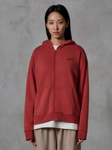 Alpinestars Essentials Ageless Zip Hoodie, teglrød, afslappet streetwear, vist på en model, design med fuld lynlås og hætte, lille sort Alpinestars-logo på brystet, afslappet pasform, kompakt fleece