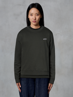 Alpinestars Essentials Ageless Crew, premium crewneck sweatshirt, Off Black, med et lille hvidt Alpinestars-logo på brystet, afslappet streetwear-stil båret af en model med mørke jeans