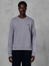 Alpinestars Essentials Ageless Crew, sølvfarvet crewneck sweatshirt båret af en model, med et lille sort stjernelogo på brystet, afslappet pasform med ribbede manchetter og kant, afslappet motorsport streetwear