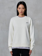 Alpinestars Essentials Ageless Crew, crewneck sweatshirt, off-white, med et lille sort Alpinestars-logo på brystet, afslappet livsstilstøj vist på en kvinde