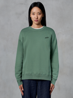 Alpinestars Essentials Ageless Crew, crewneck sweatshirt, kaktusgrøn, bæres af en model, lille sort logo på brystet, ribstrikket krave, manchetter og kant, afslappet motorsport streetwear
