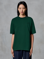 Alpinestars Essentials Ageless SS Tee, kortærmet T-shirt, fyrregrøn, båret af model, med et lille sort logo på brystet, afslappet pasform, økologisk bomuld, casual streetwear