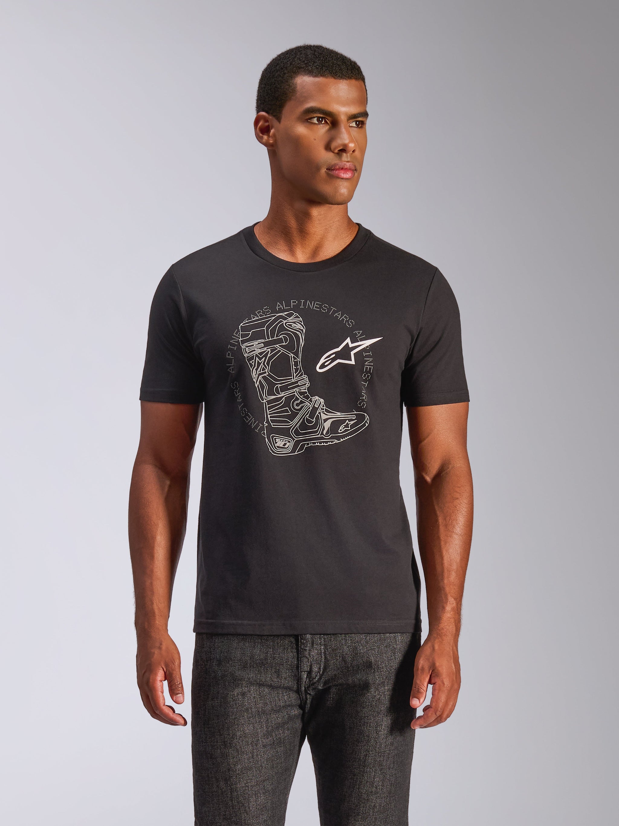 Alpinestars Tech Boot CSF Tee, kortærmet t-shirt, sort med hvid motocross-støvle-grafik og stjerne-logo, casual motorsport-streetwear, båret af mandlig model