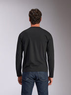 Alpinestars Trackside CSF Tee, langærmet t-shirt, sort, set bagfra, båret med mørkeblå denimjeans, afslappet motorsport-inspireret streetwear