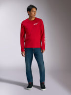 Alpinestars Trackside CSF Tee, langærmet t-shirt, rød med hvidt Alpinestars-logo, livsstilsbillede båret med blå jeans og sorte sneakers, afslappet motorsport-inspireret sportstøj