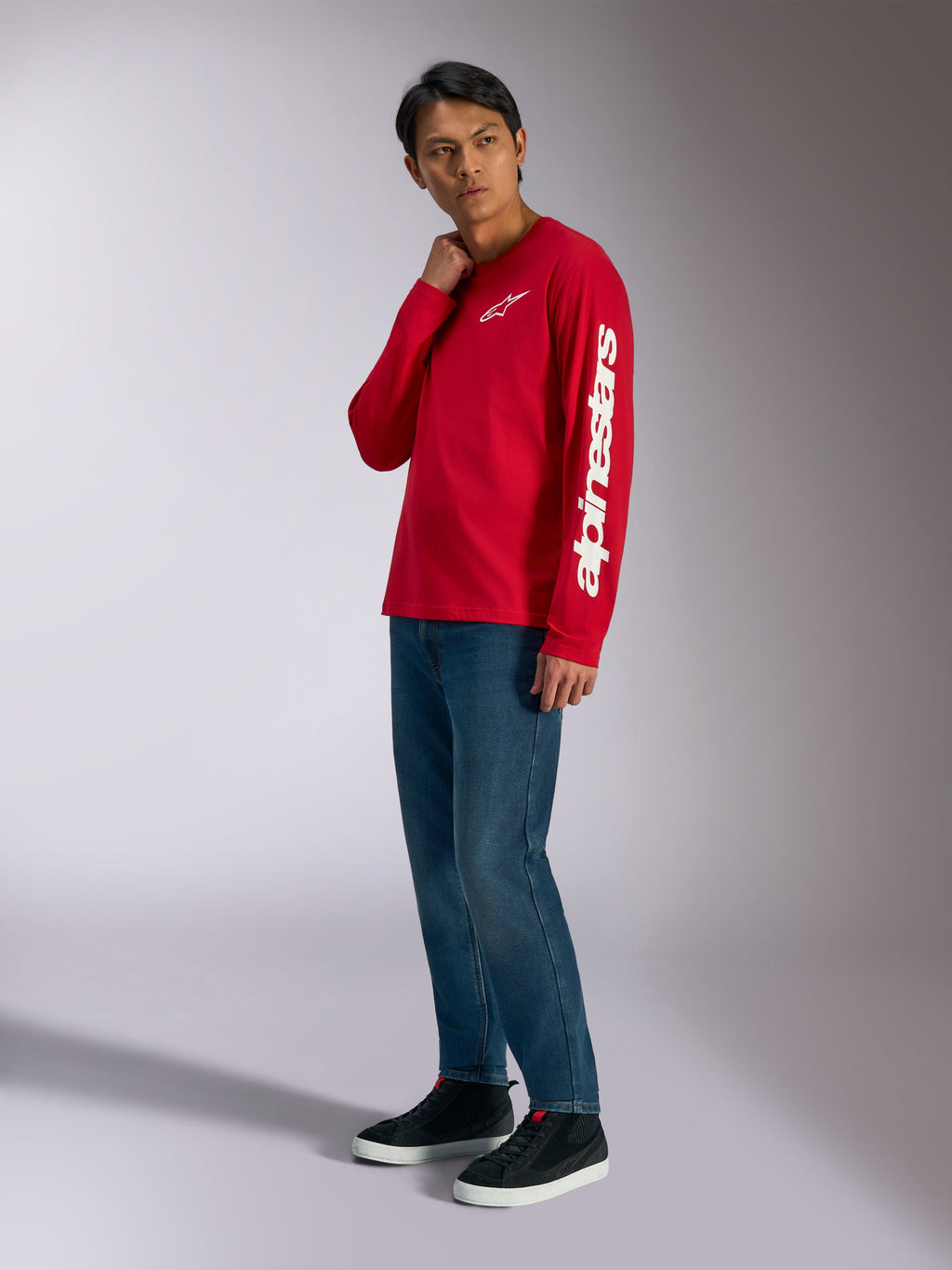 Alpinestars Trackside CSF langærmet t-shirt, rød med hvidt Alpinestars-branding på bryst og ærme, båret af model med blå jeans og sorte sneakers, casual motorsport-inspireret streetwear
