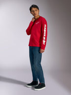 Alpinestars Trackside CSF langærmet t-shirt, rød med hvidt Alpinestars-branding på bryst og ærme, båret af model med blå jeans og sorte sneakers, casual motorsport-inspireret streetwear