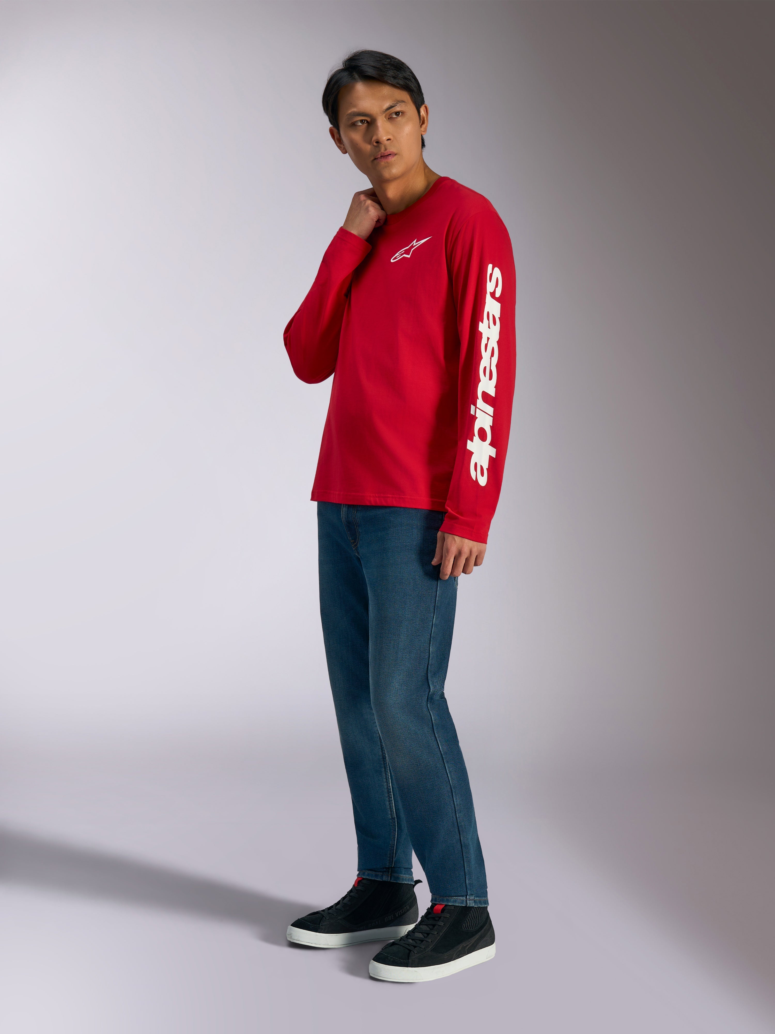 Alpinestars Trackside CSF langærmet t-shirt, rød med hvidt Alpinestars-branding på bryst og ærme, båret af model med blå jeans og sorte sneakers, casual motorsport-inspireret streetwear