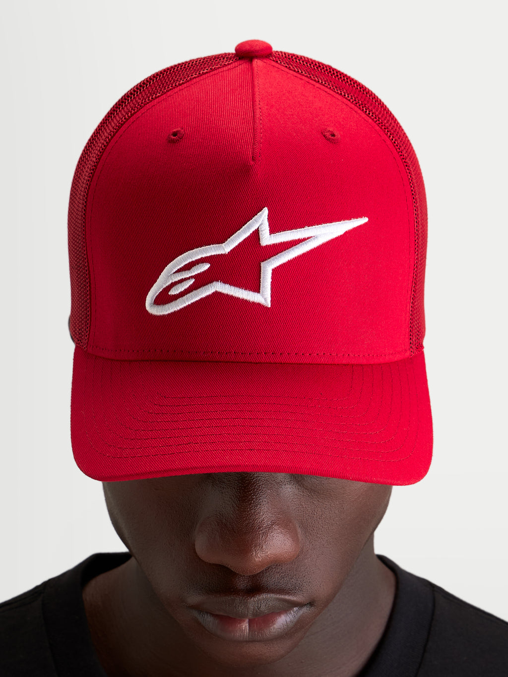 Alpinestars Ageless Snapback kasket, rød sportswear-kasket med hvidt broderet Astars-logo, struktureret krone og buet skygge båret af model