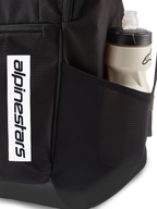 Alpinestars Defcon V3 Backpack, black daily backpack, close-up of side mesh pocket with water bottle, vertical white logo branding on front, durable 600D polyester material