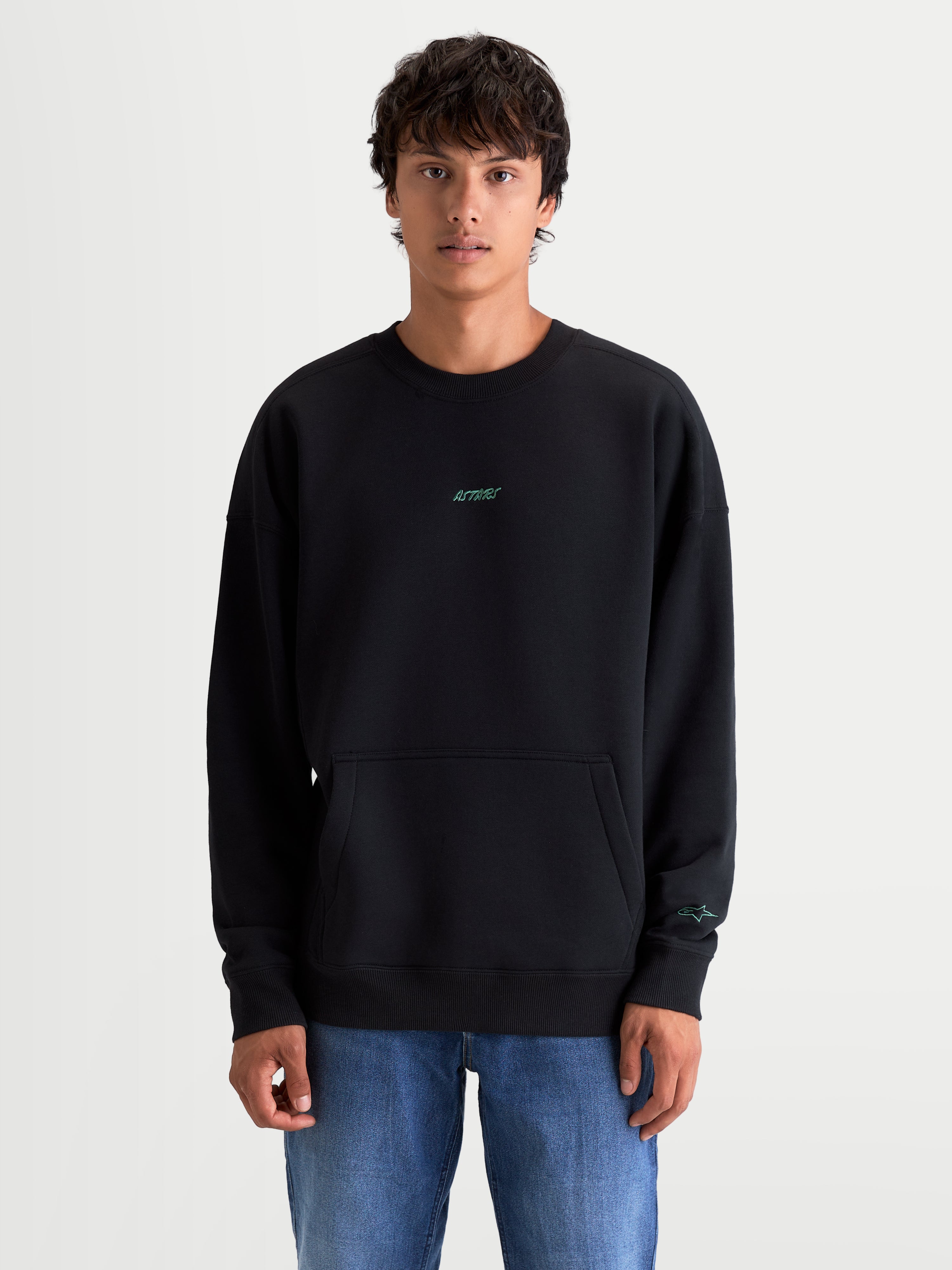 Alpinestars Guise Oversized Crew, sort fleecepullover i oversized pasform med kængurulomme, blågrønne broderede Astars-logoer på bryst og ærme, blød konstruktion i bomuld og genanvendt polyester.