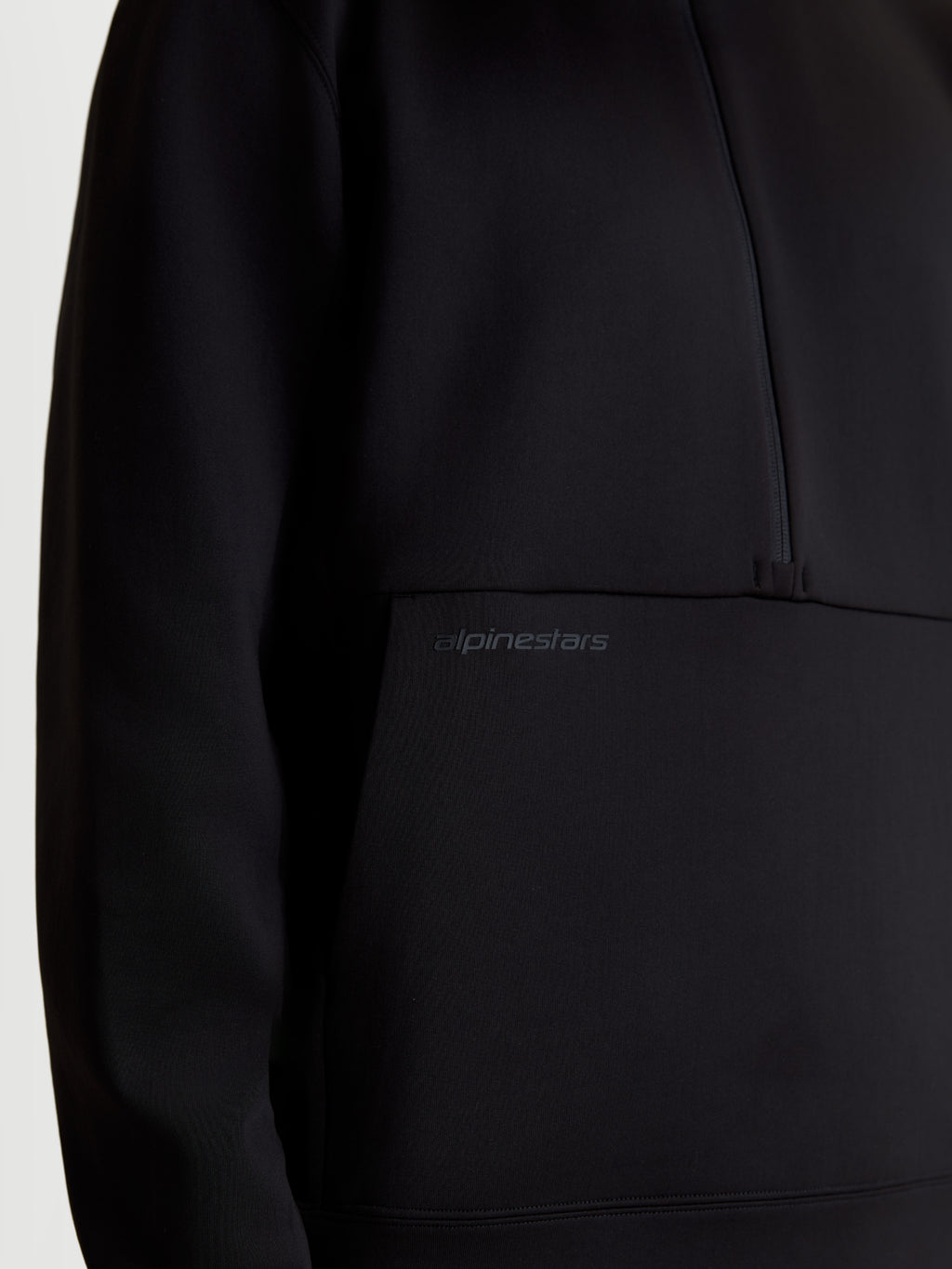 Alpinestars Apera Half-Zip Sweatshirt, sort unisex sportswear-sweatshirt, tætbillede af tonalt HD-logotryk på kængurulommen og detalje med halv lynlås, premium tri-blend fleece-konstruktion.