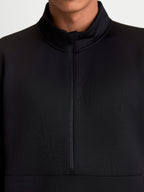 Alpinestars Apera Half-Zip sweatshirt, sort sportspullover, tætbillede af frontens halve lynlås og høje krave, on-model visning, fremstillet i tri-blend fleece med et tonalt Alpinestars-logo for et rent motorsport-inspireret look.