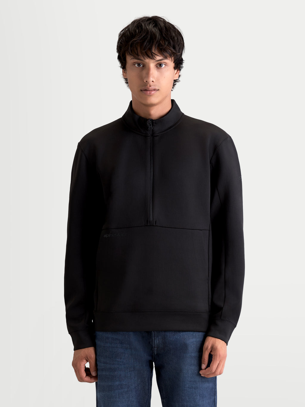 Alpinestars Apera Half-Zip sweatshirt, sort unisex sportswear-pullover i fleece, kængurulomme og halvlynlås, tonalt HD-logotryk, motorsport-inspireret design til hverdagsbrug, vist på model.