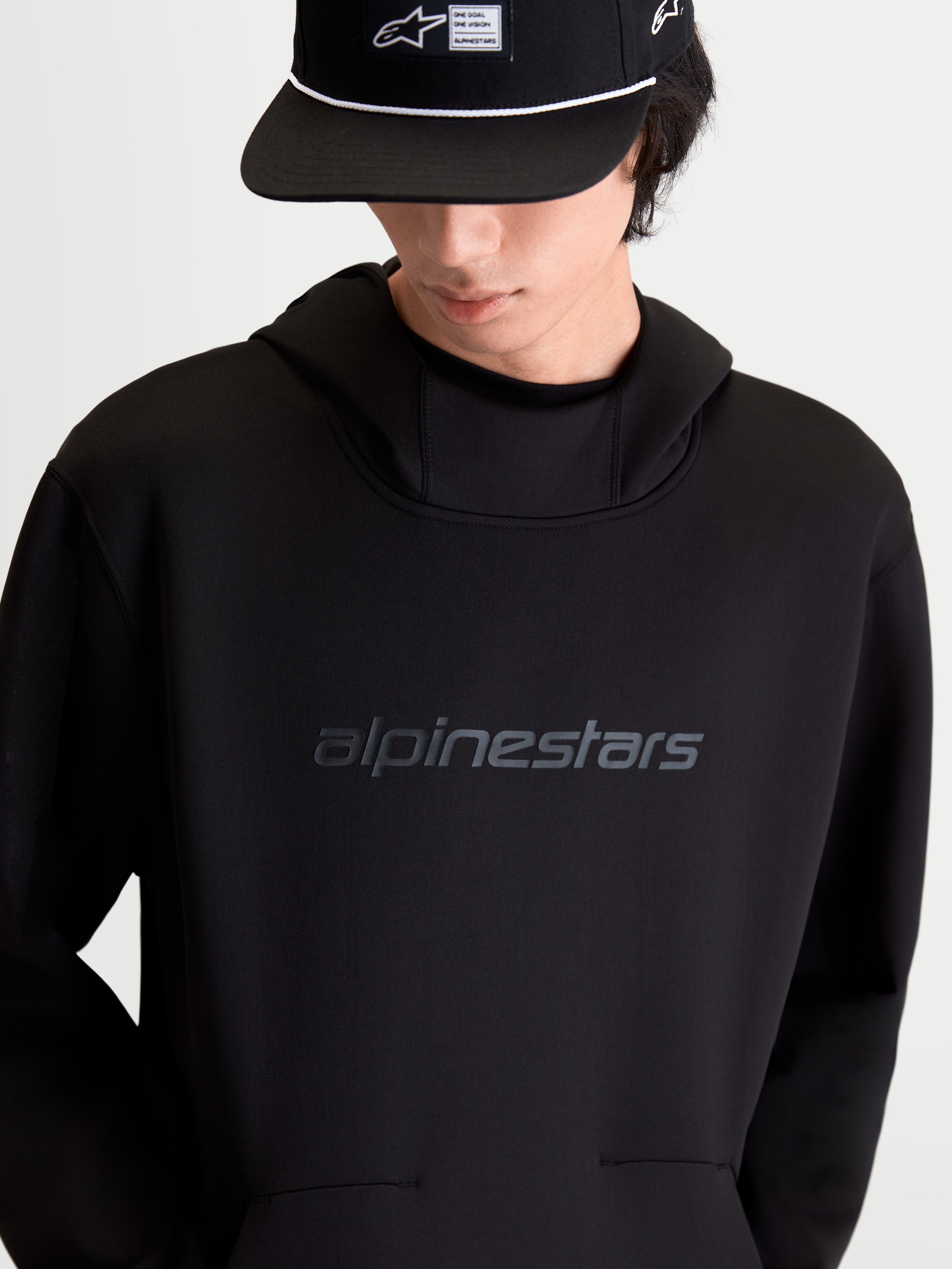 Alpinestars Datrix Hættetrøje, sort pullover-hættetrøje i tri-blend dobbeltsidet fleece, tonalt HD-logo på brystet og mesh-foret hætte, on-model forfra, casual motorsport-inspireret sportstøj.