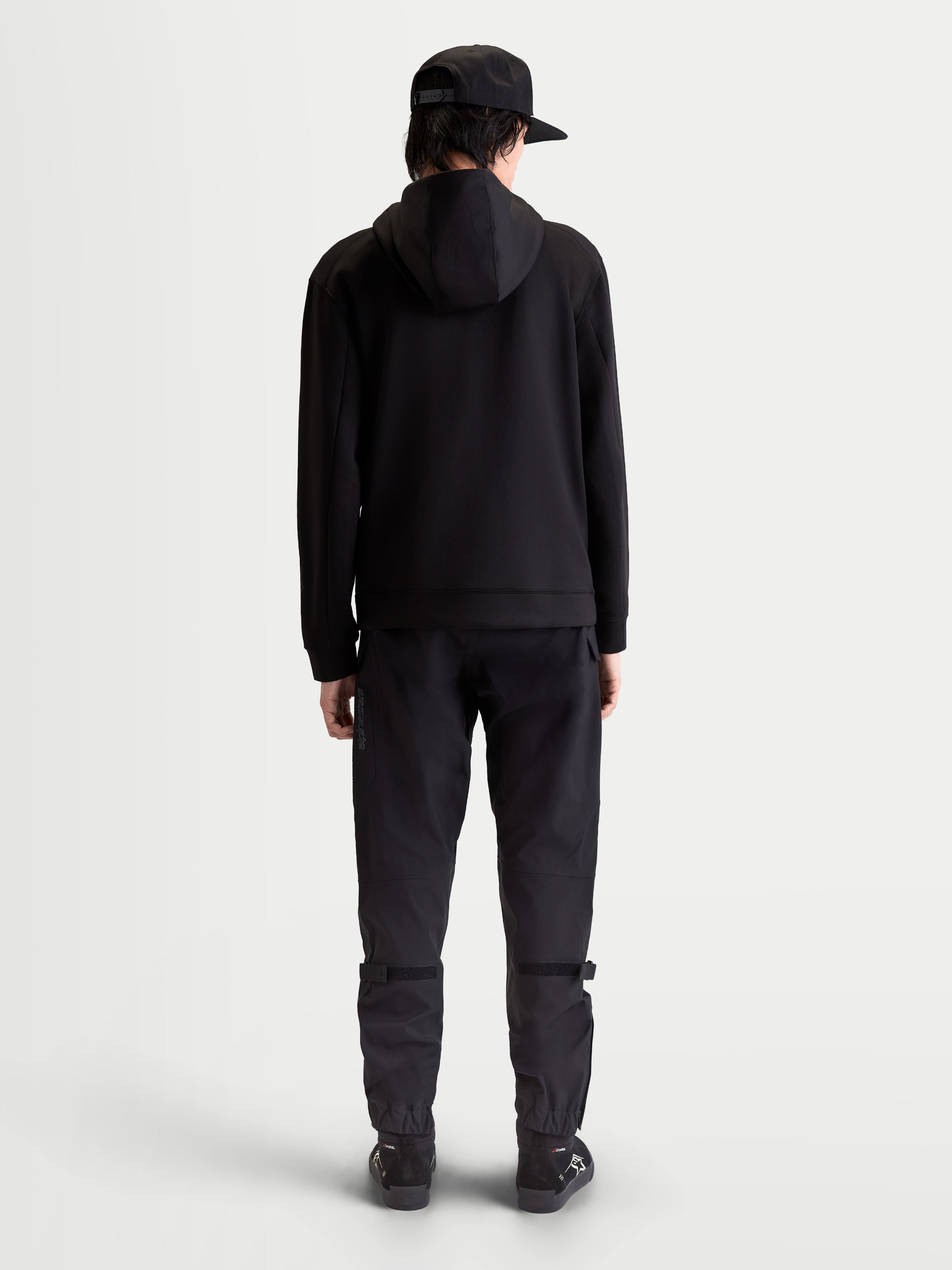 Alpinestars Datrix hættetrøje, premium sportstøj pullover, sort, set bagfra på model, tri-blend dobbeltsidet fleece med mesh-foret hætte og motorsport-inspireret stil.