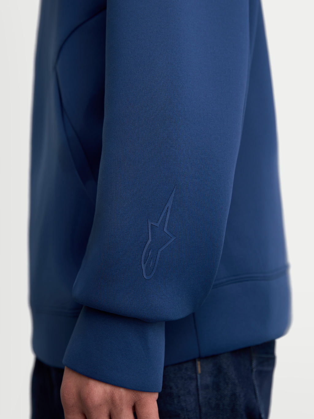 Alpinestars Datrix Hættetrøje, premium sportswear pullover i blå, nærbillede af ærmet med et tonalt HD Alpinestars-logo, fremstillet i blød dobbeltsidet fleece til afslappet hverdagsbrug