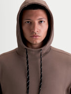 Alpinestars Camino Textured Oversized hættetrøje, brun casual sportswear pullover til herrer og damer, tekstureret strikket twill-fleece, høj krave og hætte med sort-hvide mønstrede snører.