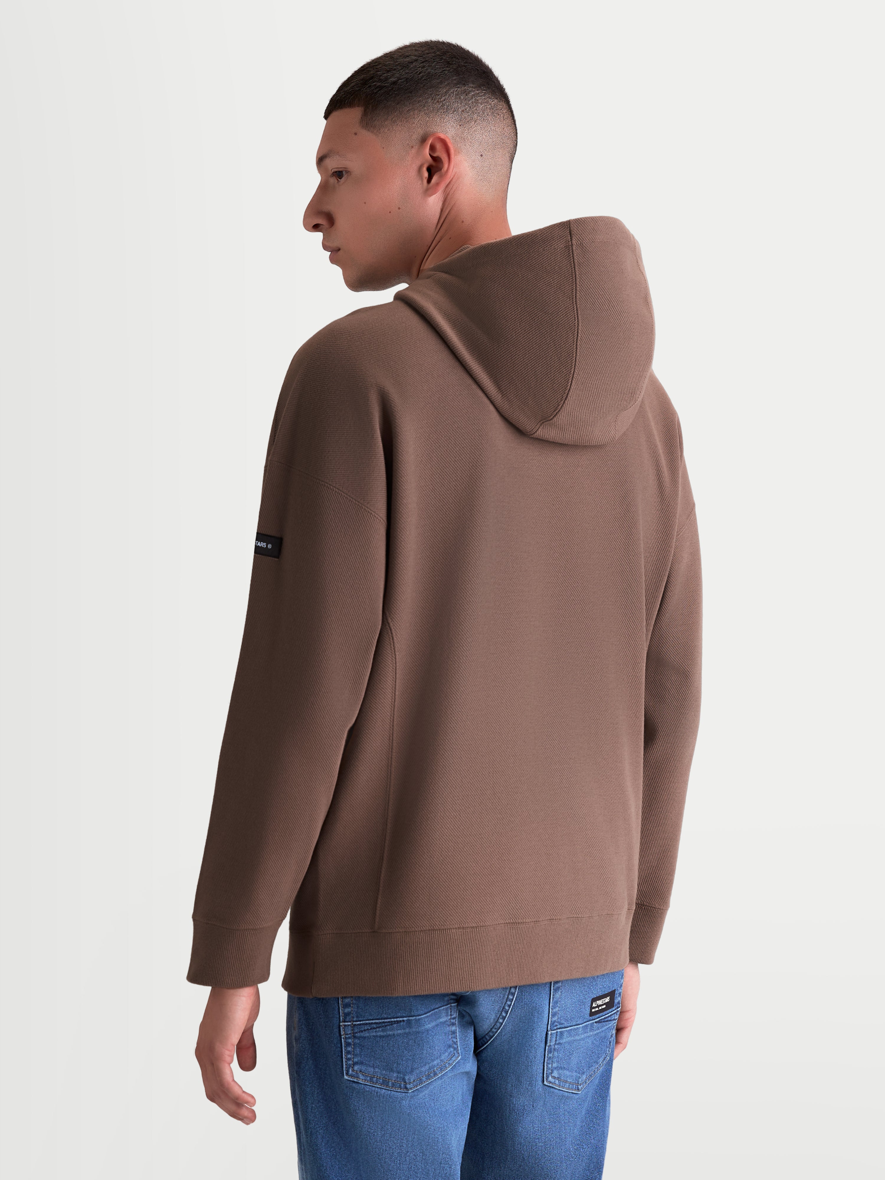 Alpinestars Camino Textured Oversized hættetrøje, afslappet sportstøjspullover til mænd og kvinder, brun, tekstureret strikket twill-fleece, set bagfra med afslappet pasform og branding på ærmet