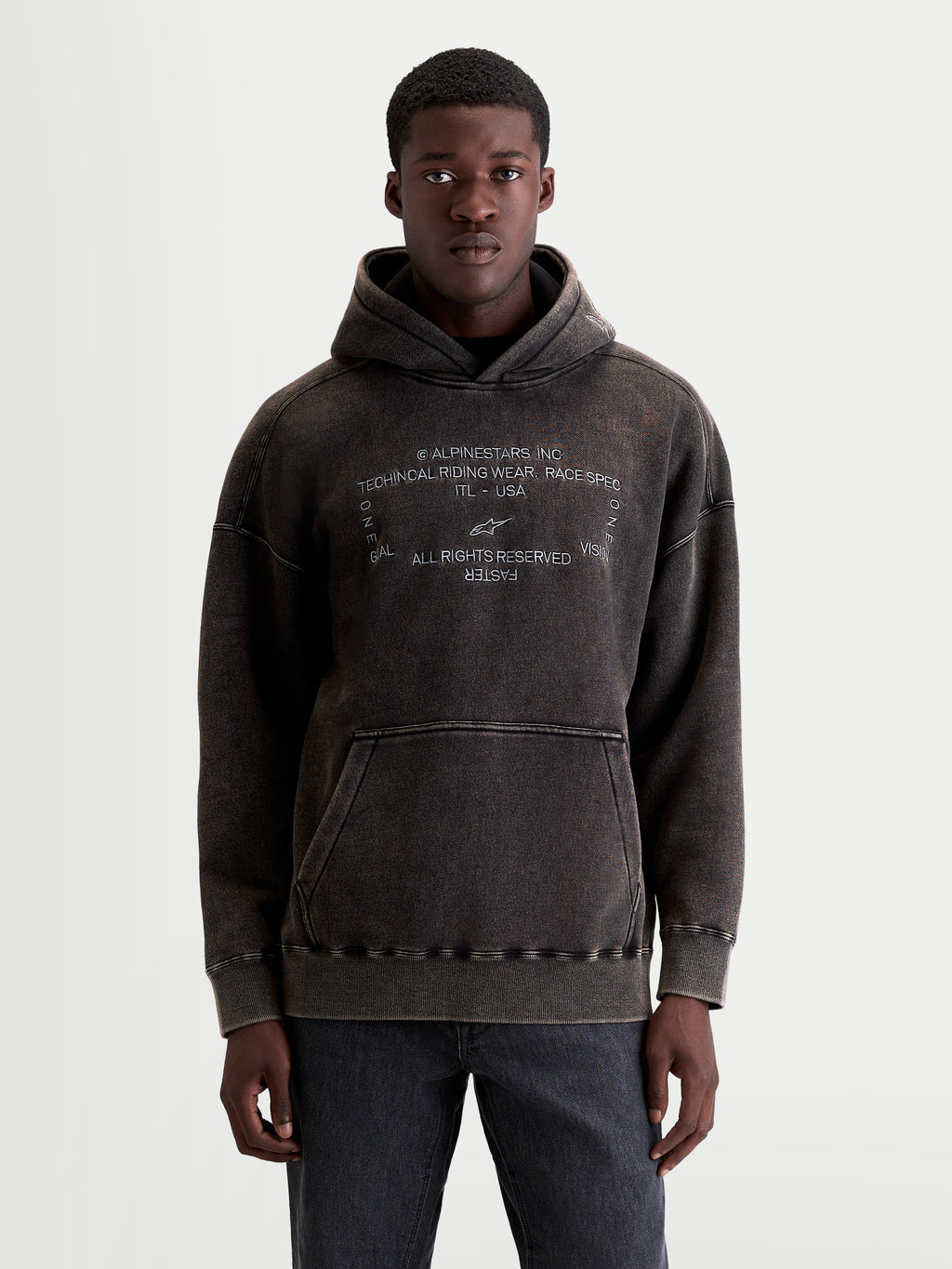 Alpinestars Infinite Washed Oversized Hættetrøje, vasket sort sportswear pullover i snevasket fleece med kængurulomme og hvidt broderet Alpinestars logo-tekst, model set forfra