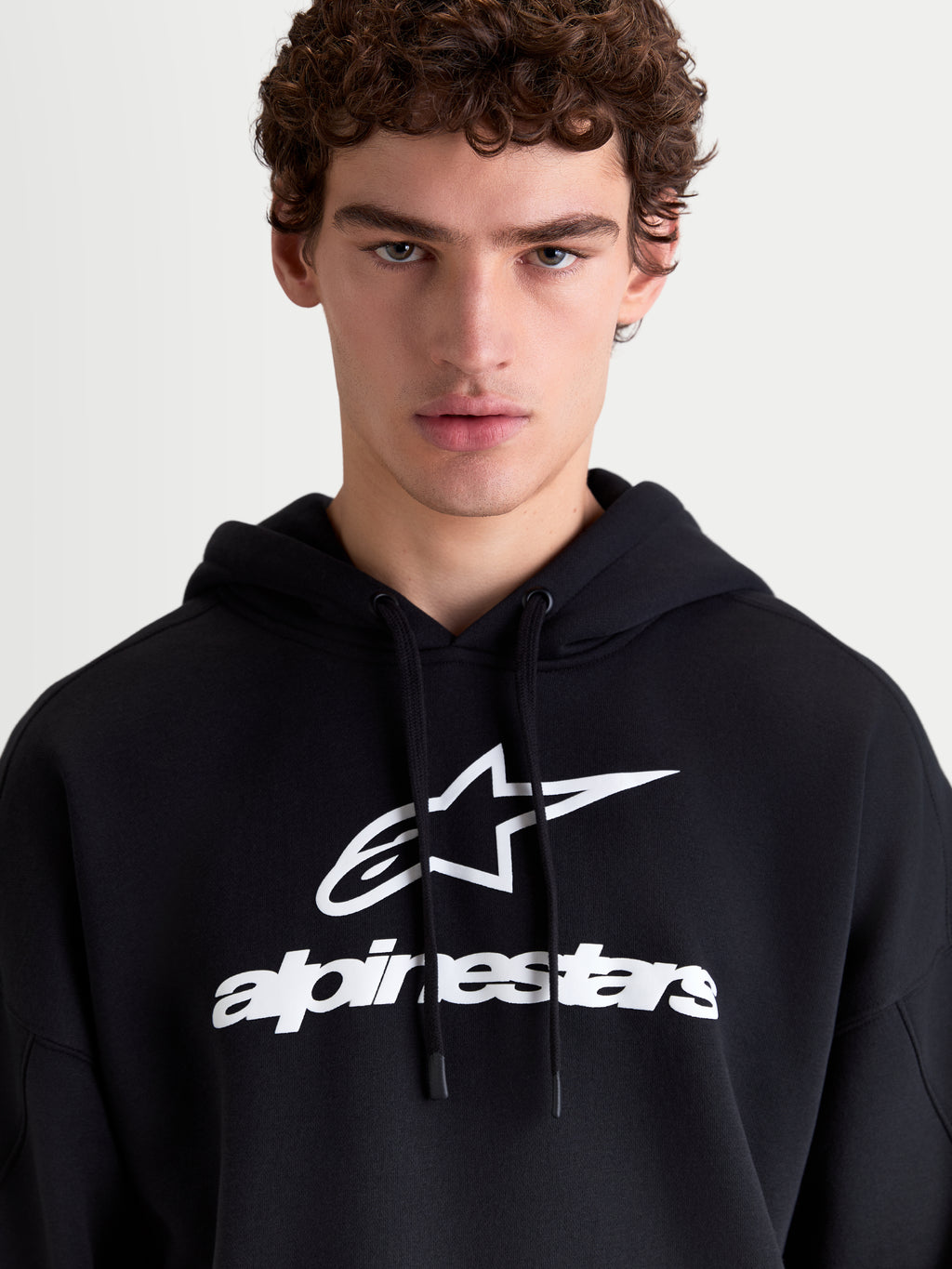 Alpinestars Prelude Oversized hættetrøje til herrer, sort og hvid fleece-pullover med hvidt puff-printet logo på brystet, oversized pasform, afslappet sportswear til hverdagsbrug.