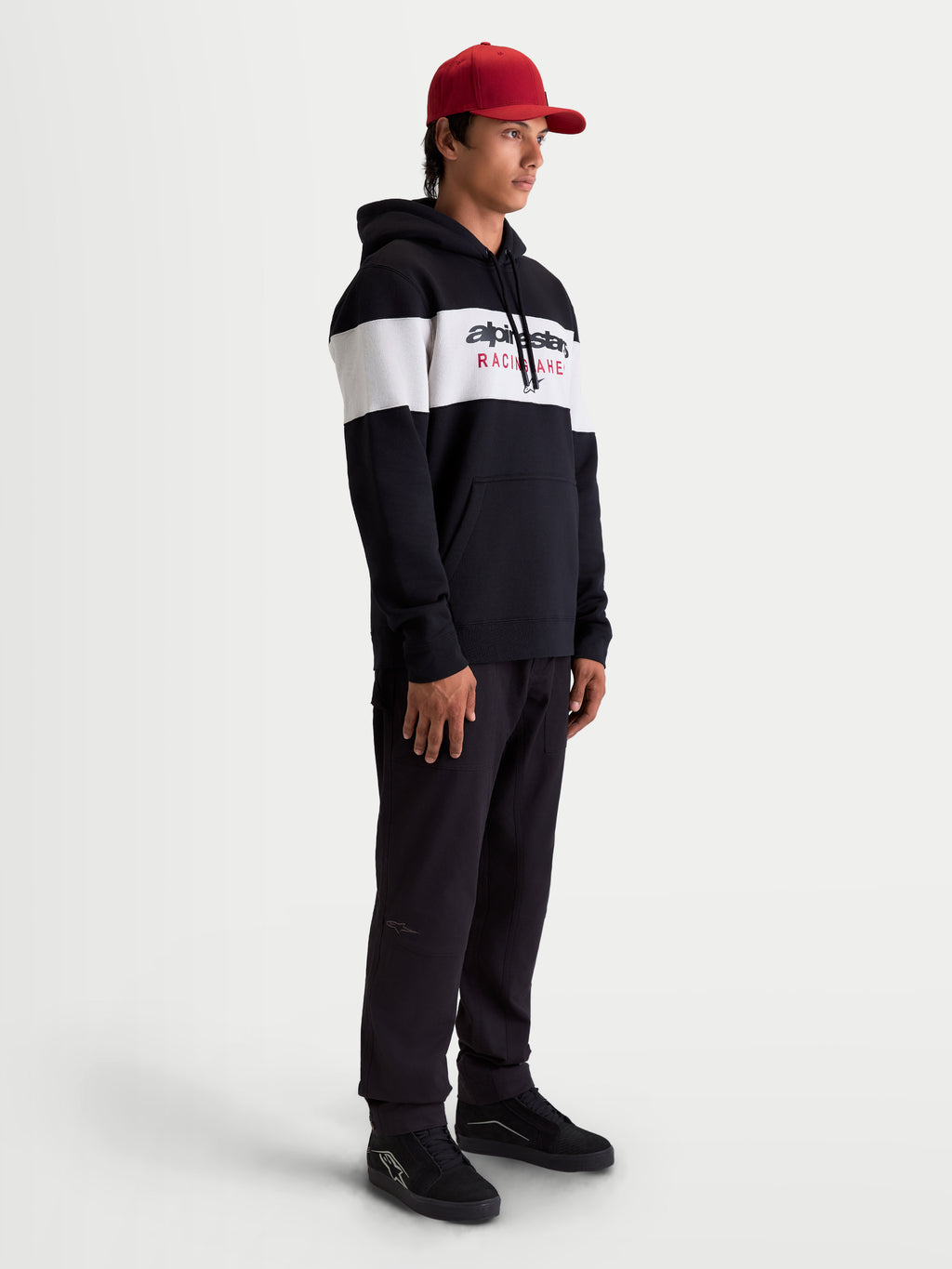 Alpinestars Cubic Hættetrøje, herre-sportswear-hættetrøje i fleece, sort og hvidt farveblokeret design med Alpinestars logo på fronten, blød bomuldsblanding, vist på model i en livsstilssammenhæng