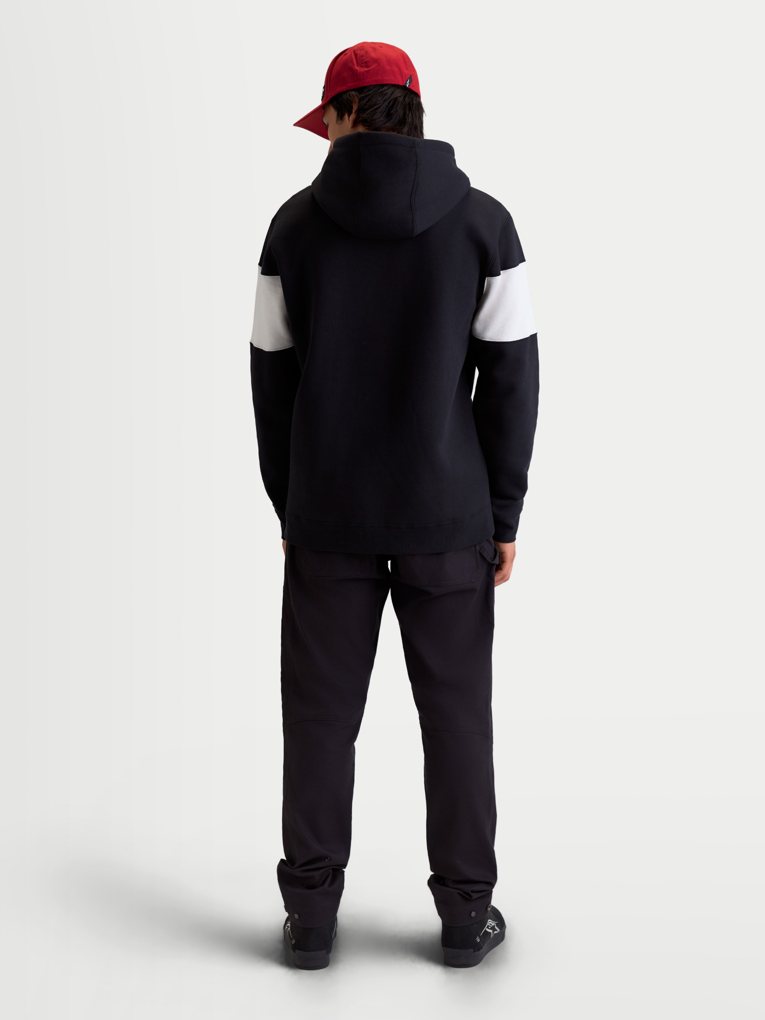 Alpinestars Cubic hættetrøje, unisex sportswear-hættetrøje i fleece, sort og hvid med farveblokerede ærmer, set bagfra på model, premium bomuldsblanding, afslappet hverdagstøj til brug væk fra motorcyklen.