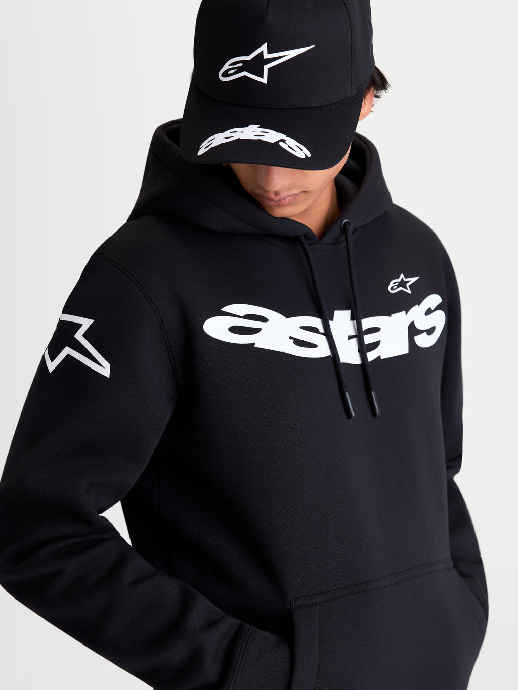 Alpinestars Velocifier hættetrøje, premium sportswear pullover i fleece, sort og hvid, med markant hvid Astars-tekst på brystet og logo på skulderen, afslappet hverdagstøj til motorsportsentusiaster.