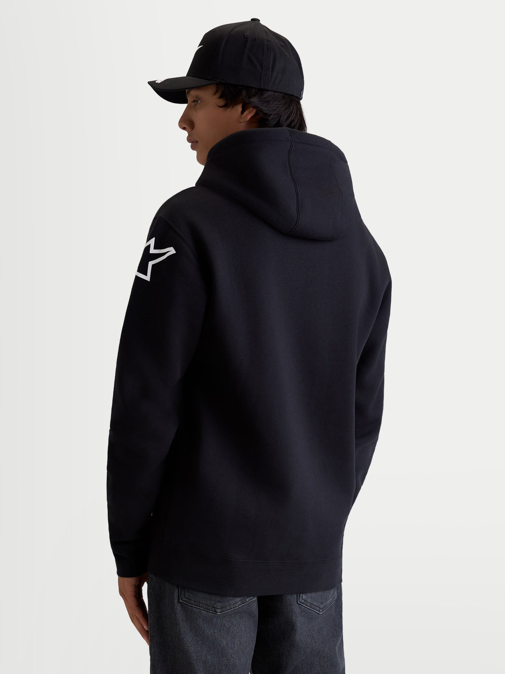 Alpinestars Velocifier hættetrøje, sort herre-fleecepullover med hvidt Astars-logo på skulderen, fremstillet i bomuld og genanvendt polyester, afslappet sportstøj til motorsportsentusiaster, set bagfra på model.