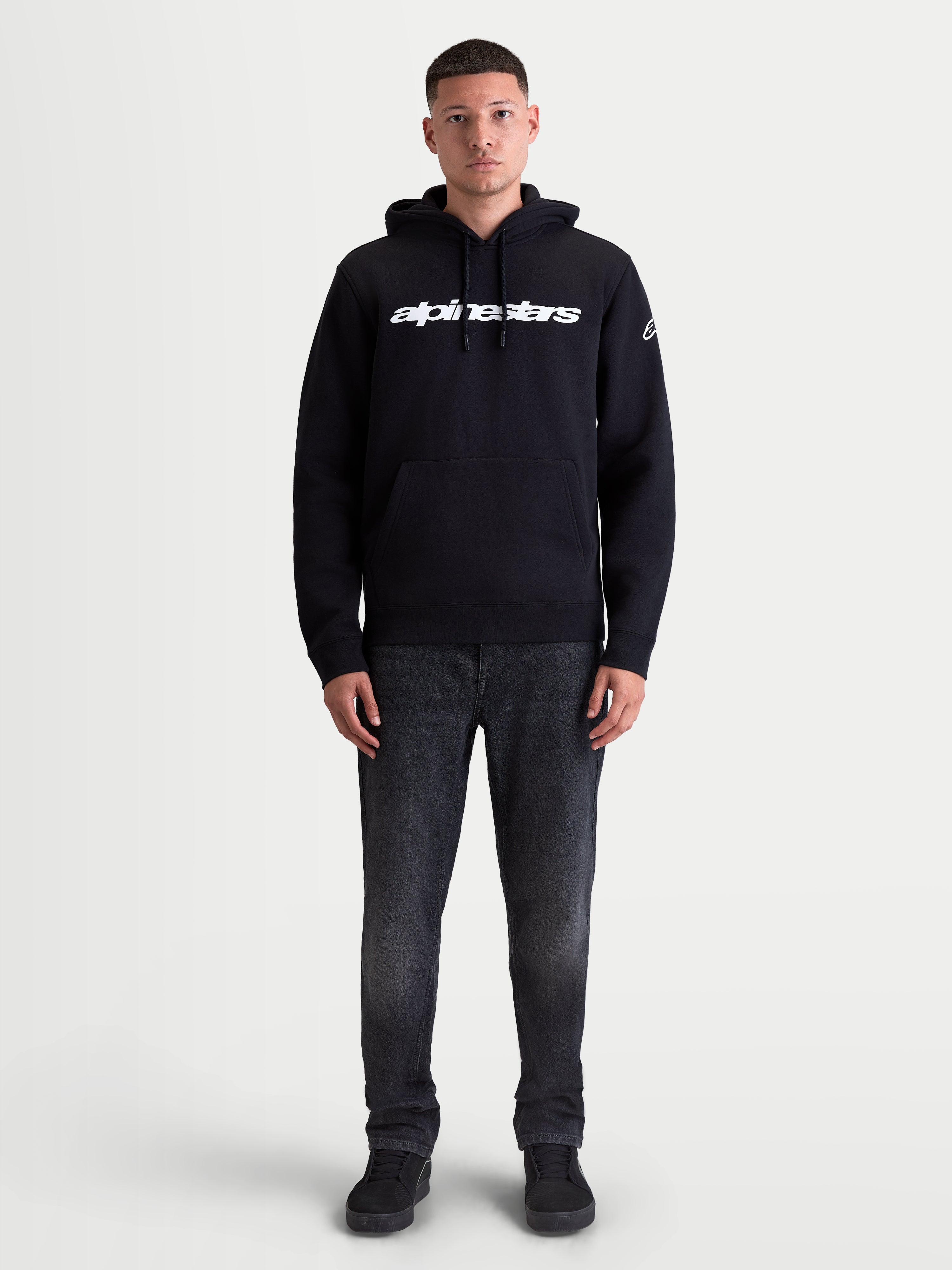 Alpinestars Race Wordmark Hoodie, Unisex Sportswear Pullover Fleece, Black and White, technical cotton and recycled polyester blend, featuring bold front Race Linear Word logo and Ageless sleeve graphic, designed for casual comfort with a self-lined drawstring hood and kangaroo pocket.
