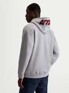 Alpinestars Pioneer Oversized hættetrøje, zip-fleece til sport og fritid, unisex, cementgrå og rød, afslappet oversized pasform med broderet rødt logo på hætten, set bagfra på model.