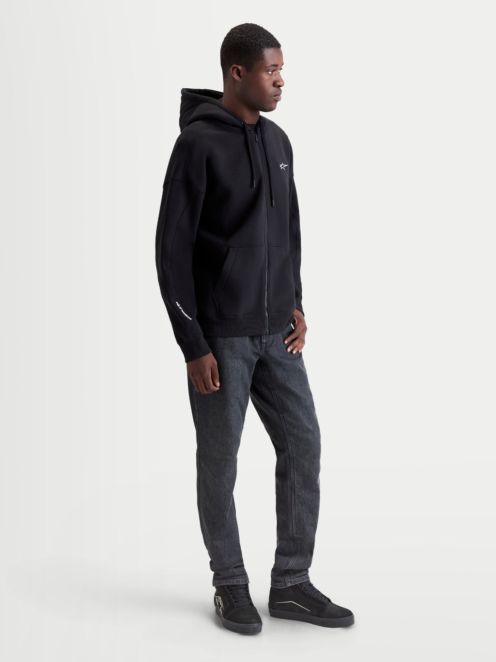 Alpinestars Entity Oversized hættetrøje, sort herrehættetrøje med lynlås og hvidt broderet logo, oversized pasform, premium bomuldsfleece, afslappet motorsport sportstøj.