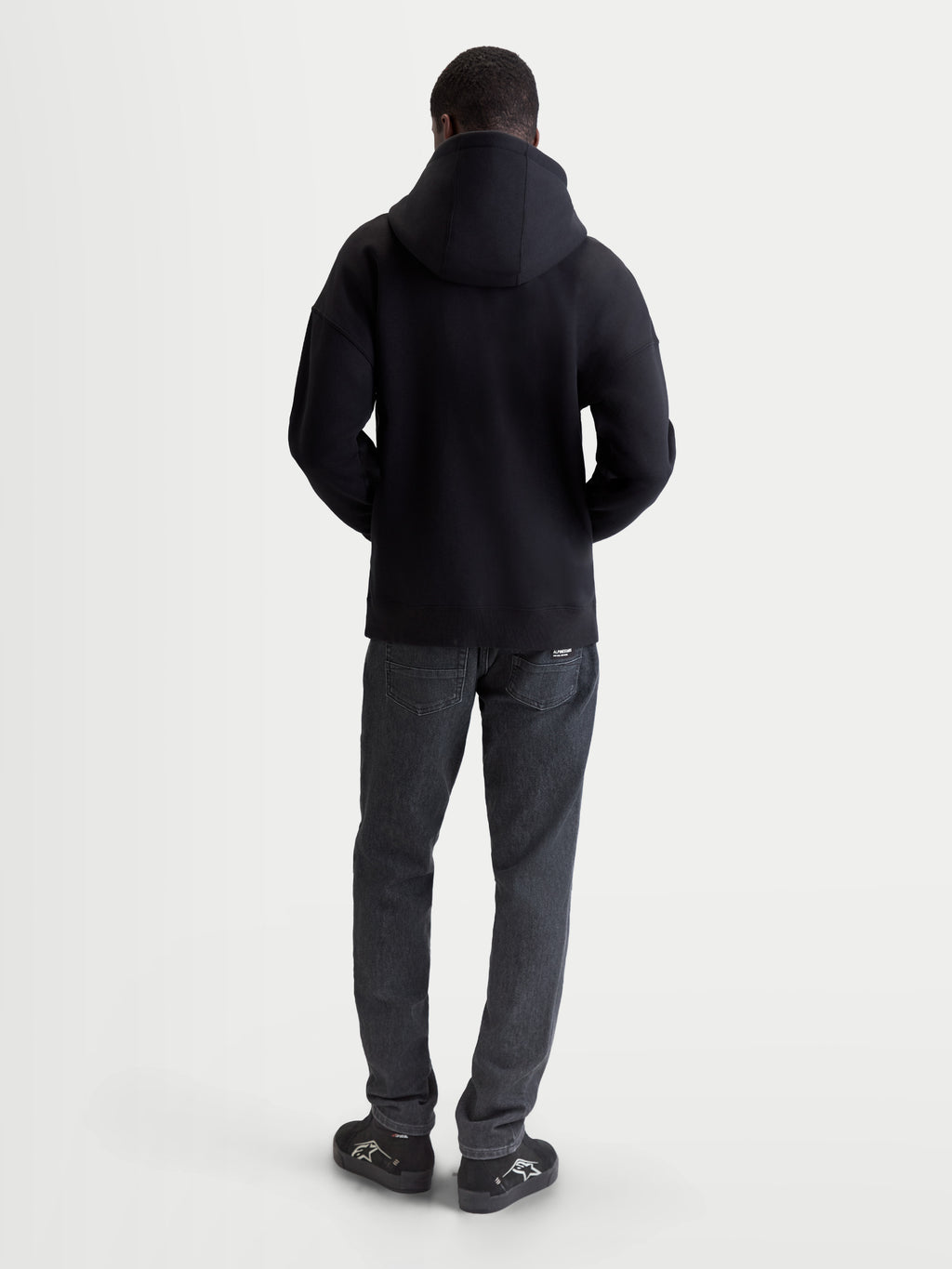 Alpinestars Entity Oversized hættetrøje, herre-sportswearhættetrøje med lynlås, sort, set bagfra på model, afslappet oversized pasform, bomulds- og genanvendt polyesterblanding, afslappet motorsportstøj