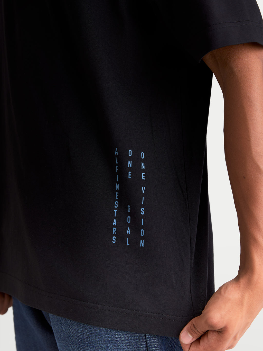 Alpinestars Chalk Oversized CSF T-shirt, kortærmet sportswear t-shirt, sort og blå, lodret ONE GOAL ONE VISION-branding på siden, afslappet oversized pasform, premium bomulds- og polyesterblanding, detalje på model