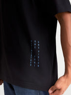 Alpinestars Chalk Oversized CSF T-shirt, kortærmet sportswear t-shirt, sort og blå, lodret ONE GOAL ONE VISION-branding på siden, afslappet oversized pasform, premium bomulds- og polyesterblanding, detalje på model