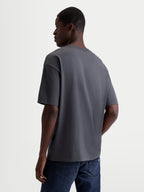Alpinestars Chalk Oversized CSF T-shirt, mørkegrå casual sportstøj T-shirt til herrer og damer, set bagfra i trekvart profil på model, der viser den afslappede oversized pasform og premium bomuld-polyester-blanding.
