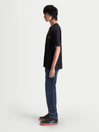 Alpinestars Latitude Oversized CSF Tee, Men's Short Sleeve Sportswear T-Shirt, Black with Orange Astars Graphic, Side Profile on Model, Relaxed Oversized Fit, Casual Everyday Style