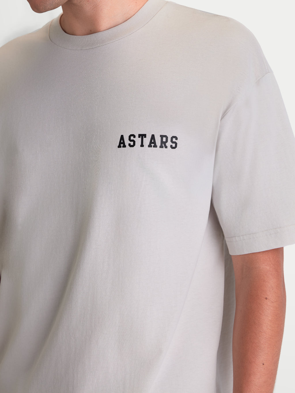 Alpinestars Latitude Oversized CSF T-shirt, kortærmet sportstøj, grå med sort ASTARS-ordmærke på brystet, afslappet oversized pasform, blød bomuldsblanding, set på model.