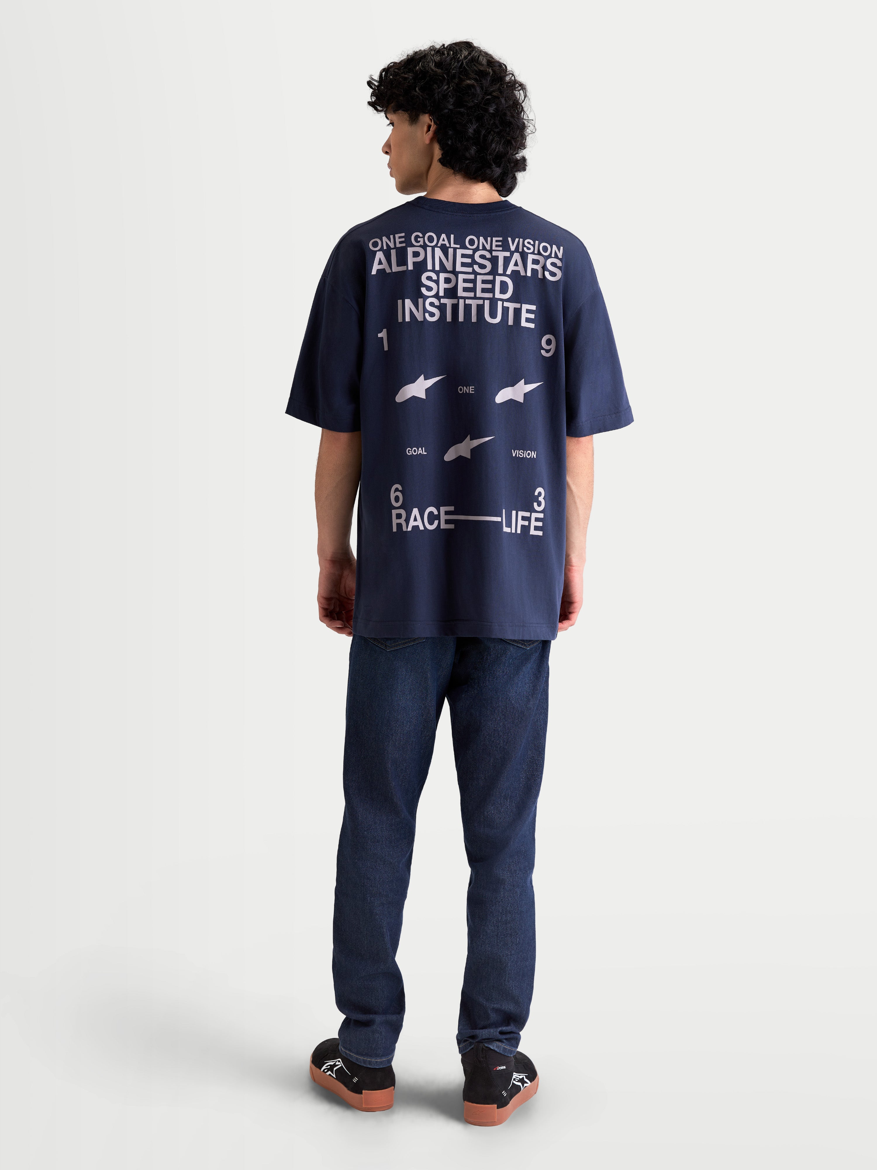 Alpinestars Institute Oversized SS CSF Tee, marineblå kortærmet T-shirt med stor hvid grafik på ryggen, 'Alpinestars Speed Institute', 'One Goal One Vision' slogan og 'Race Life' branding, afslappet oversized pasform, set bagfra på model.