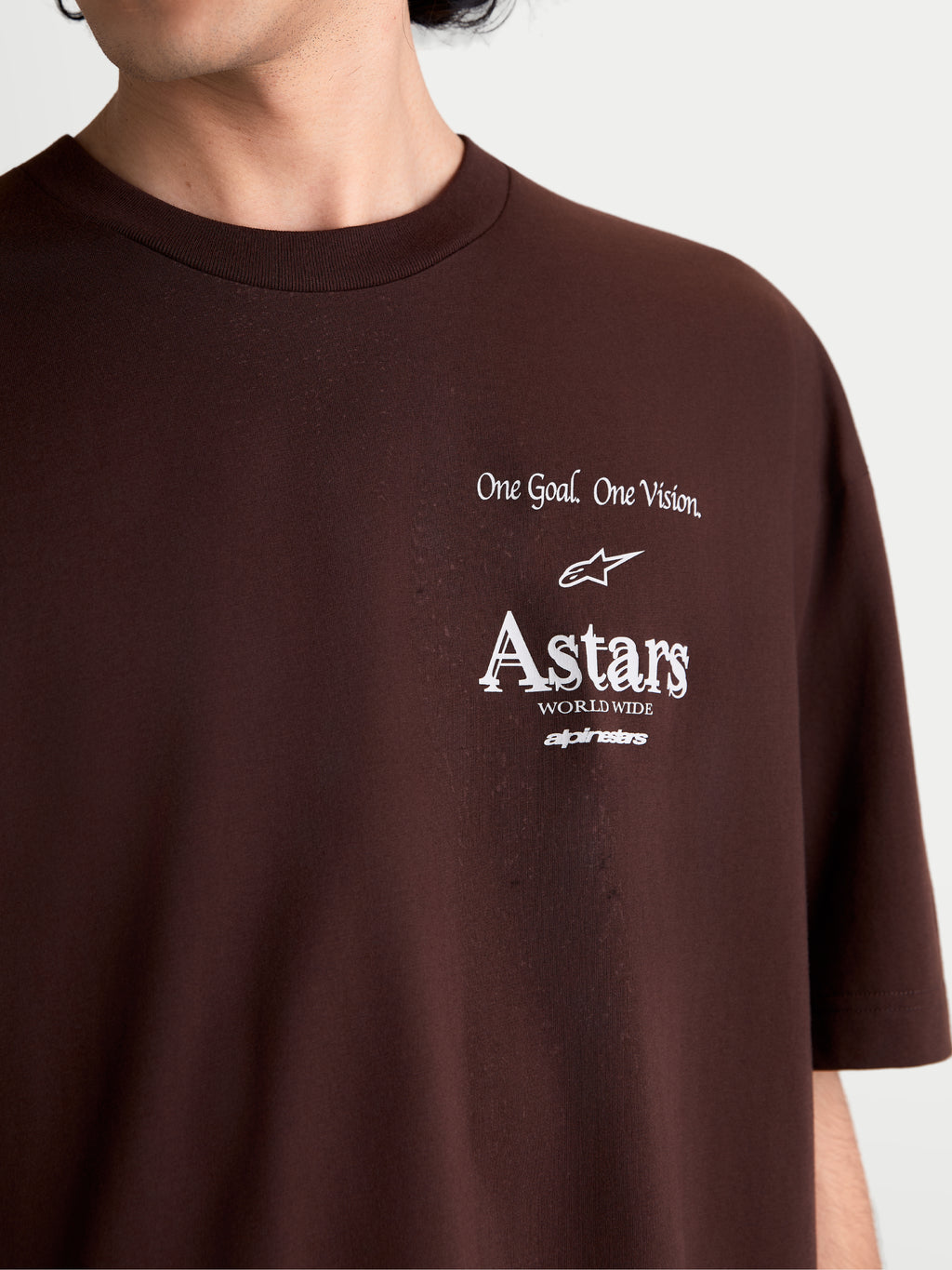 Alpinestars Post Oversized CSF T-shirt, kortærmet sportswear t-shirt, brun, tætbillede af hvid brystgrafik med One Goal. One Vision. og Astars worldwide-logo, blød bomulds-polyesterblanding